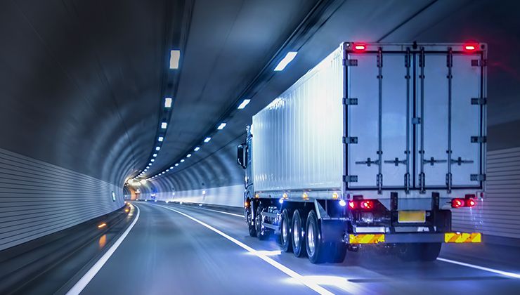 A container truck travelling through an underground tunnel in an advanced manufacturing hub