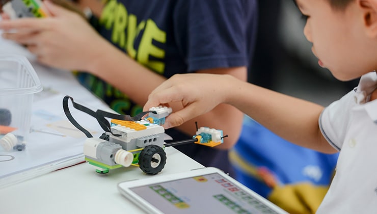 A child plays with a LEGO robot that he programmed