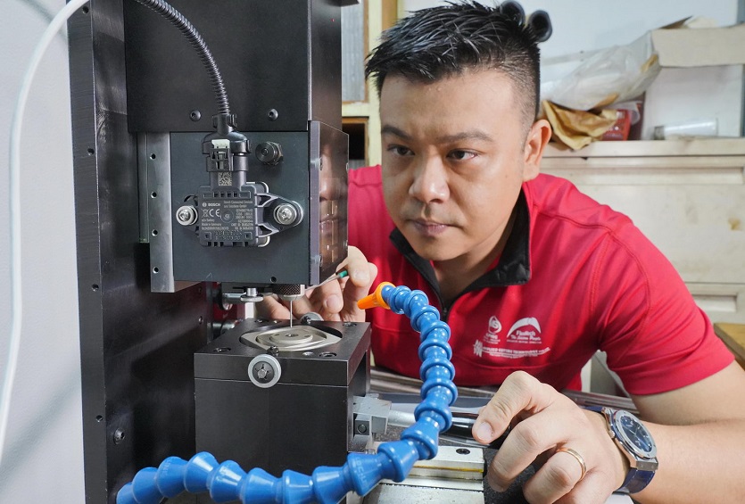 Mr Tan Ru Jin, Managing Director of Flexmech, operating the legacy machine installed with sensors that track the machine’s acoustics and vibrations.