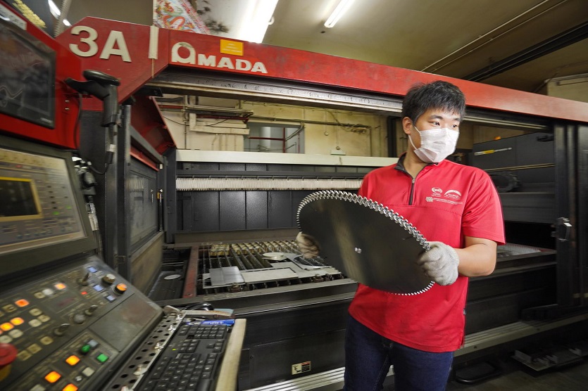 A Flexmech employee cuts out machine parts from sheet metal.