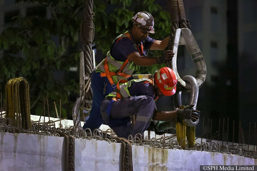 Workers hooking the beam to a crane in preparation for a bridge hoisting operation in Jurong West.