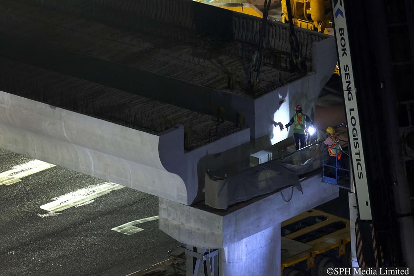 Workers checking the alignment of the beam as it is being installed over the Pan Island Expressway