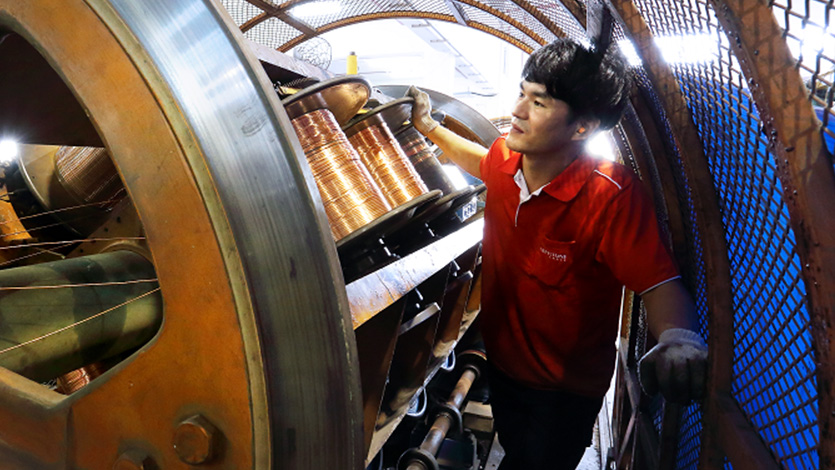 Man operates a machine that manufactures cables