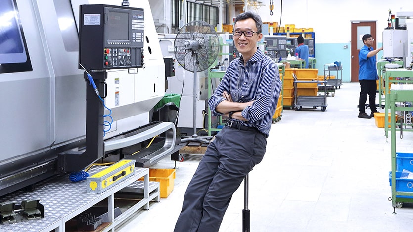 Lam Keng Yew, managing director of Onn Wah Precision Engineering, sits in front of a machine