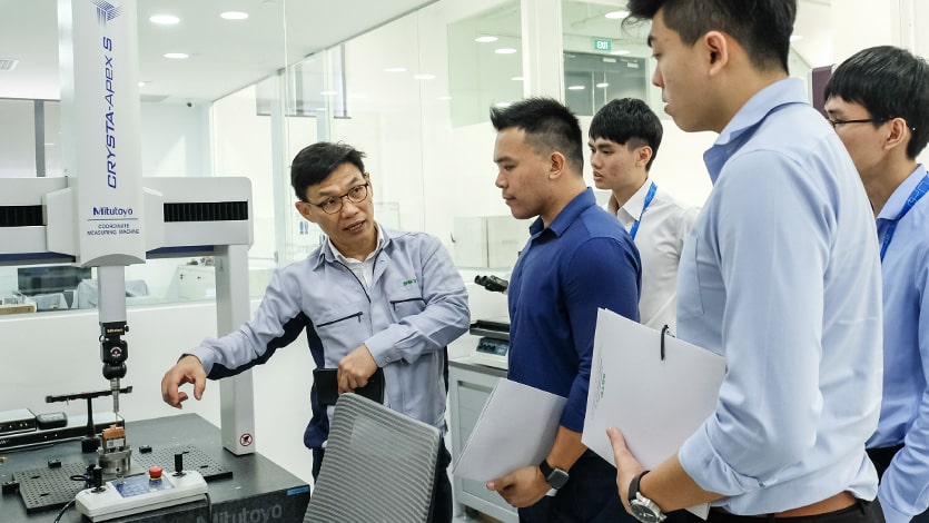 Trainees listen as a trainer shares more about 3D printers and other additive manufacturing equipment in a smart factory
