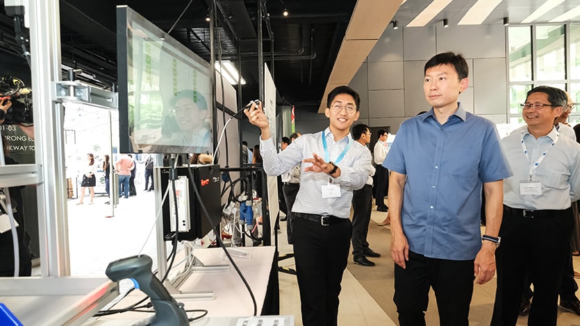 An intern shares more about a Bosch Rexroth smart workstation with Senior Minister of State Mr Chee Hong Tat