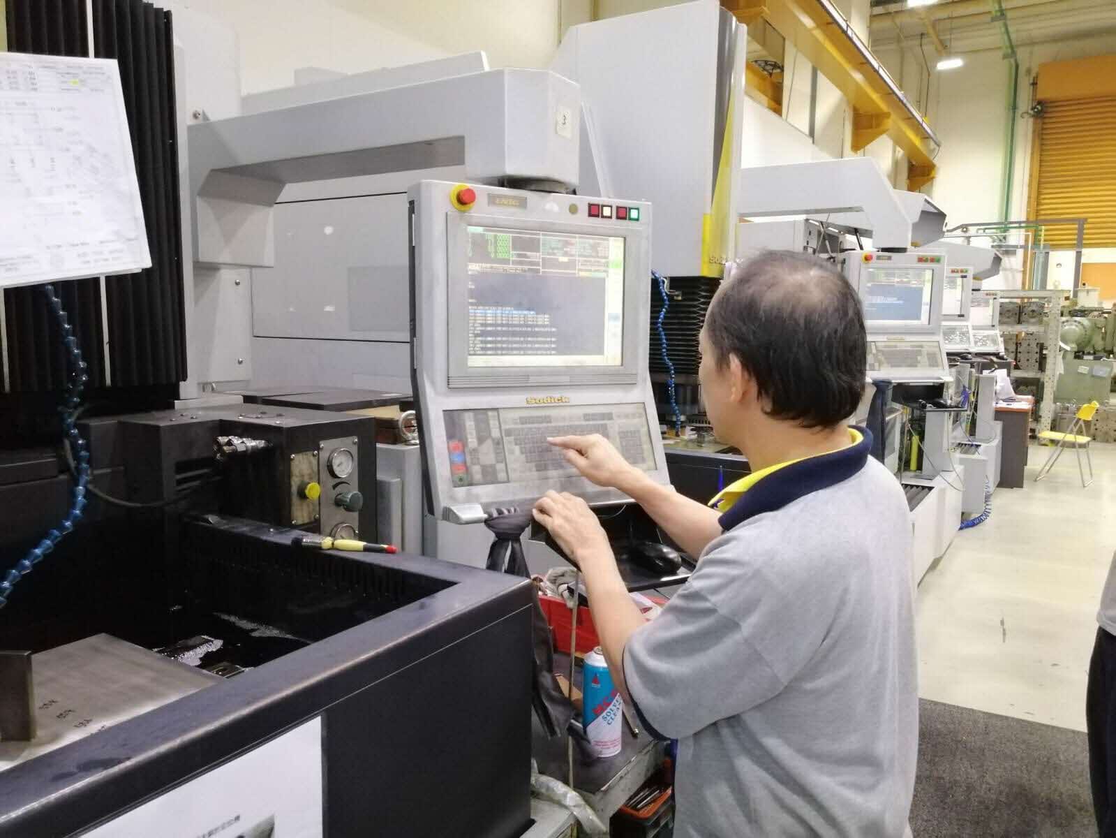 Worker handling digitized machine at Koei Tool Singapore's factory