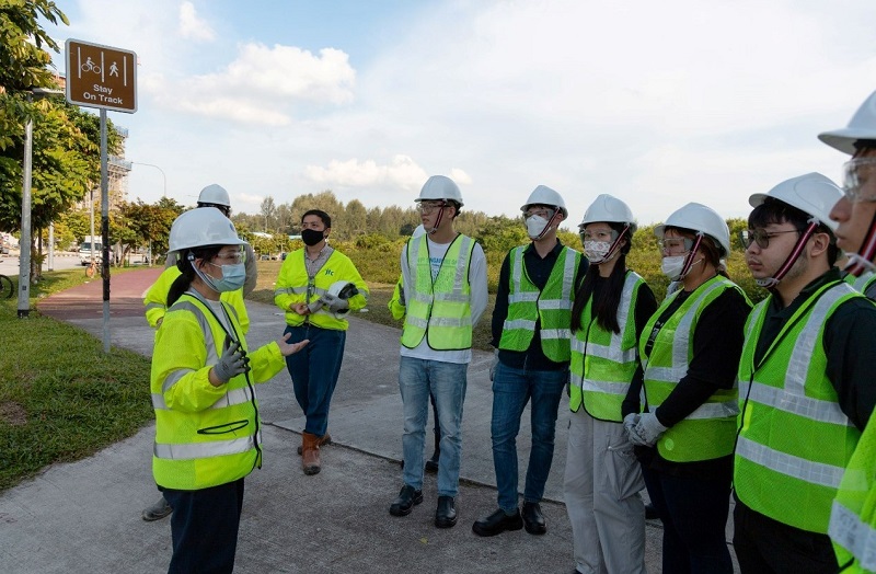 Mo Wing Sze bringing visitors on a tour of a construction site.